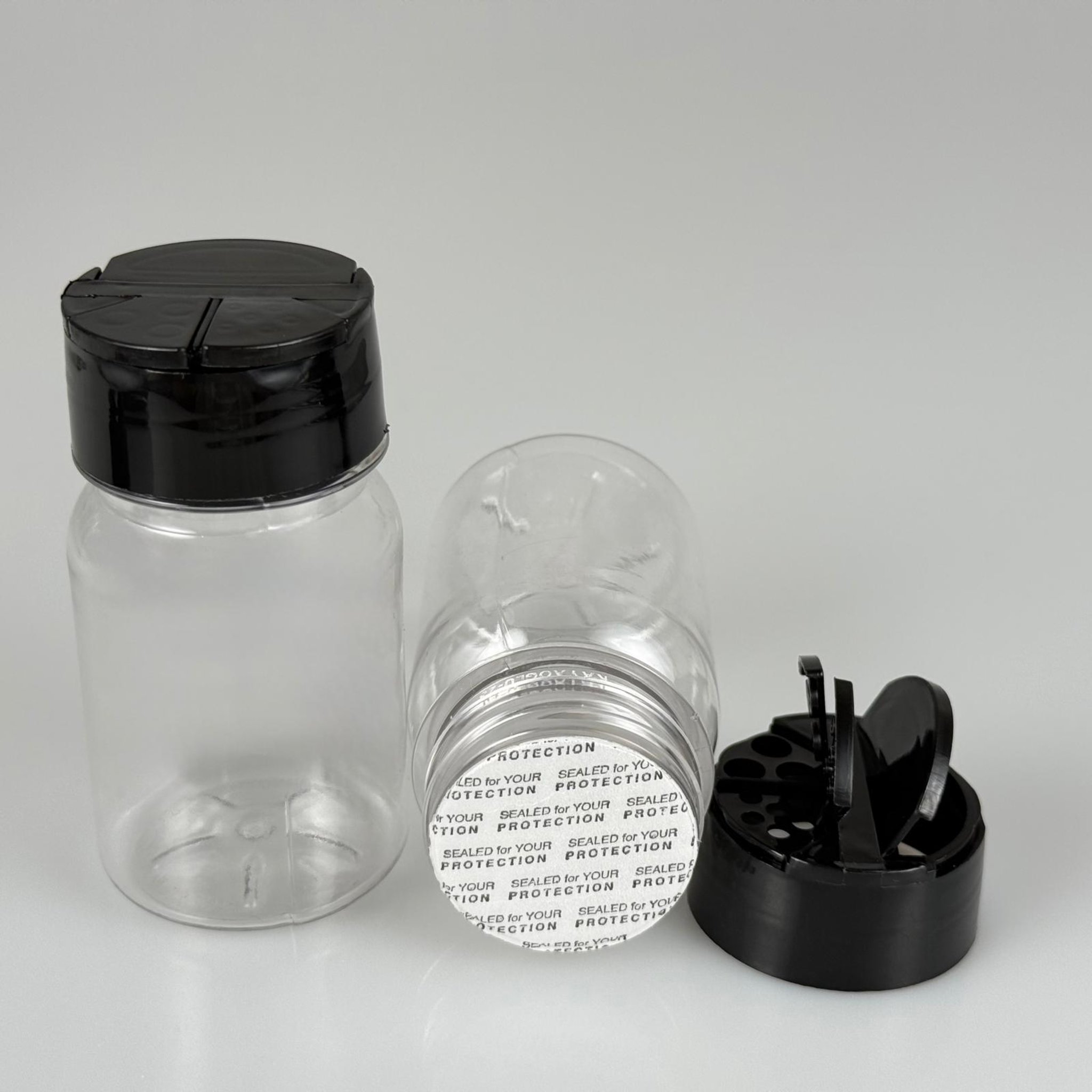 PLASTİK SİLİNDİR BAHARATLIK KAVANOZ - 100 ML PET BAHARAT, TOZ, PUDRA VB İÇİN PET ŞİŞE + SİYAH AÇILIR KAPANIR DELİKLİ KAPAKLI + KENDİNDEN YAPIŞKANLI KÖPÜK CONTALI TAKIM - 100 CC